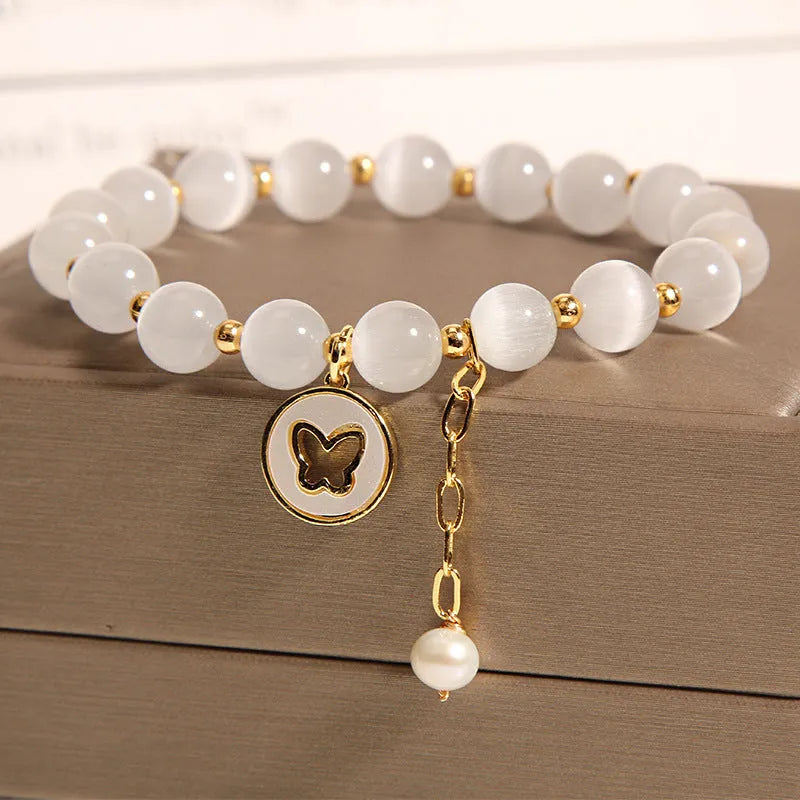 White geometric cat's eye crystal bracelet with a Korean-style design on a wrist.