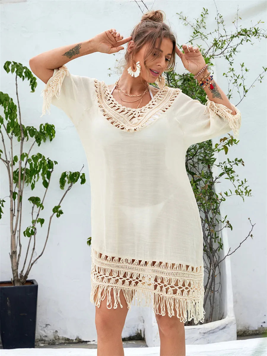 Apricot coloured hand-crocheted long beach dress for women on a hanger.
