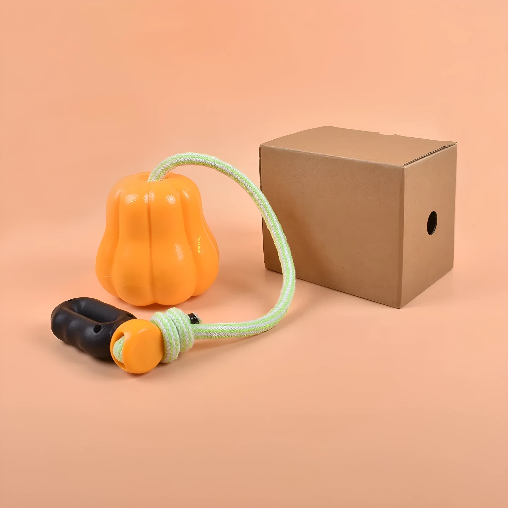 Pumpkin-coloured plastic molar dog chew toy with a blue rope attached on a white background.