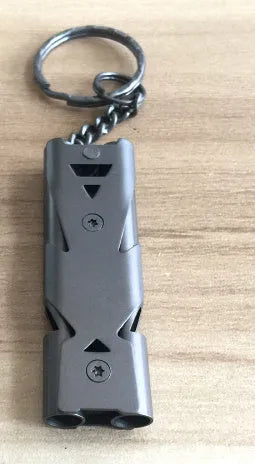 Compact keychain whistle in black and silver with keychain attachment for portable emergency signalling