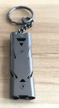 Compact keychain whistle in black and silver with keychain attachment for portable emergency signalling