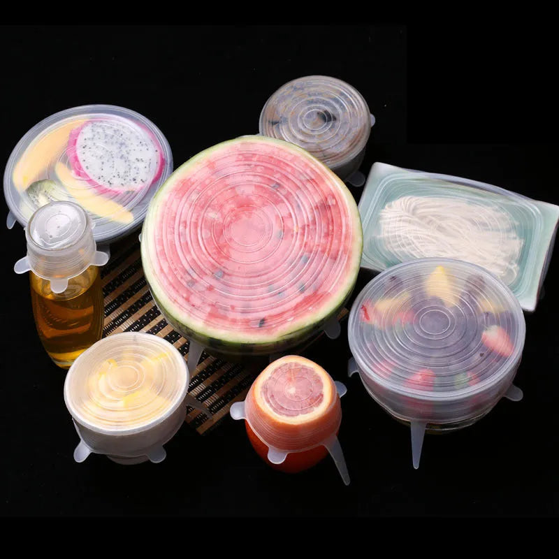 Set of six colourful silicone stretch lids in different sizes arranged on a kitchen counter.