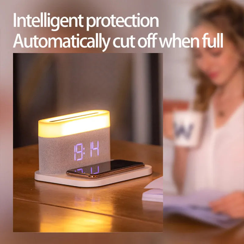 A compact black wireless charging table lamp with a digital clock display and integrated night light on a wooden desk.