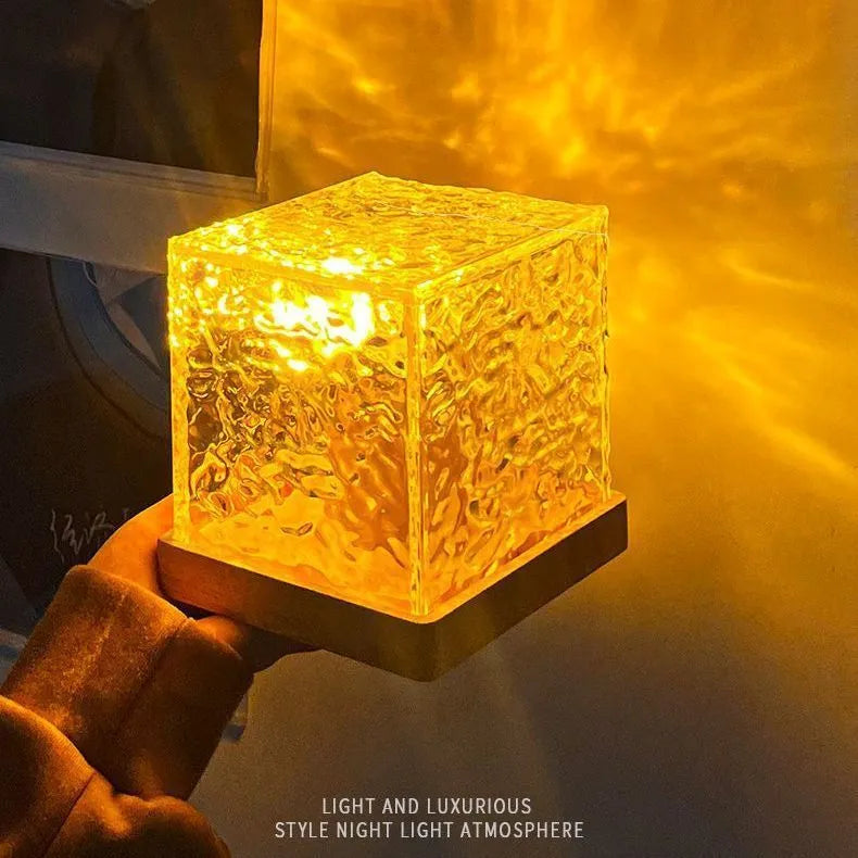 LED water ripple projection crystal table lamp with remote control on wooden surface