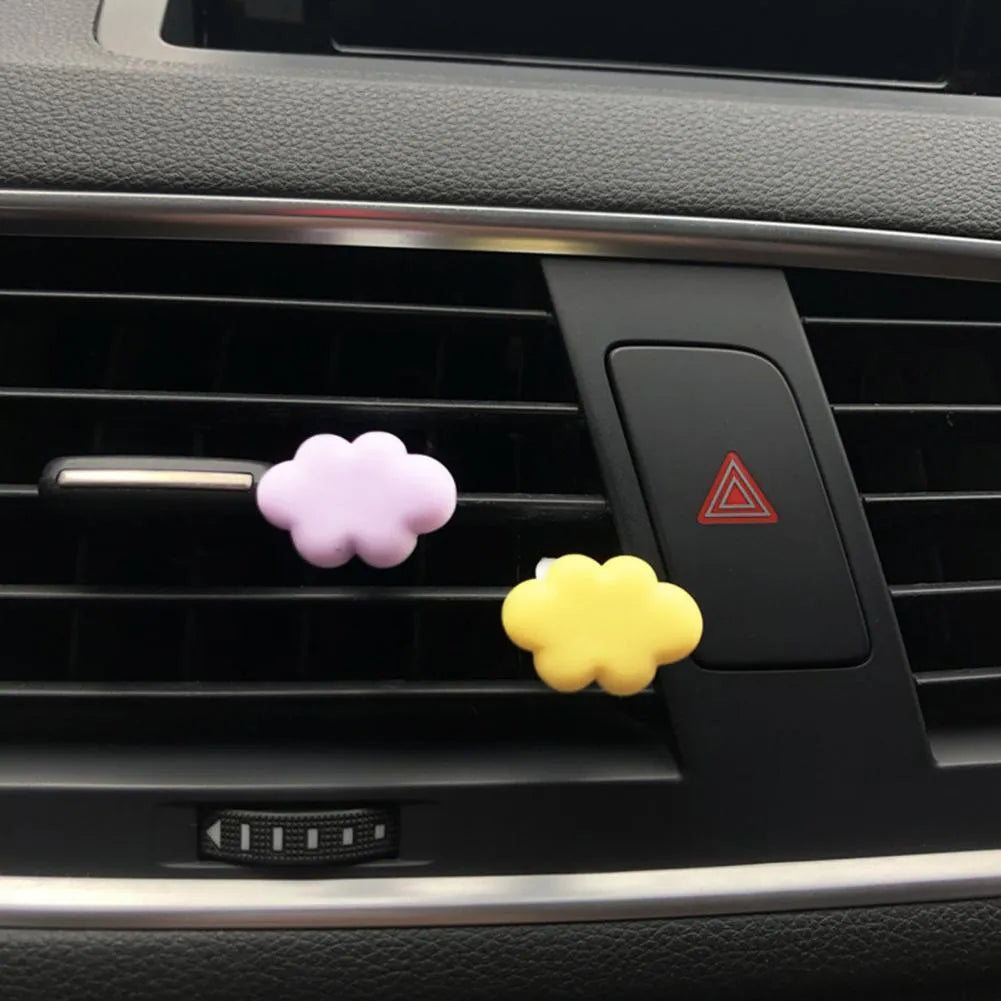 Resin cartoon cloud car air freshener clip in assorted colours on a car vent.