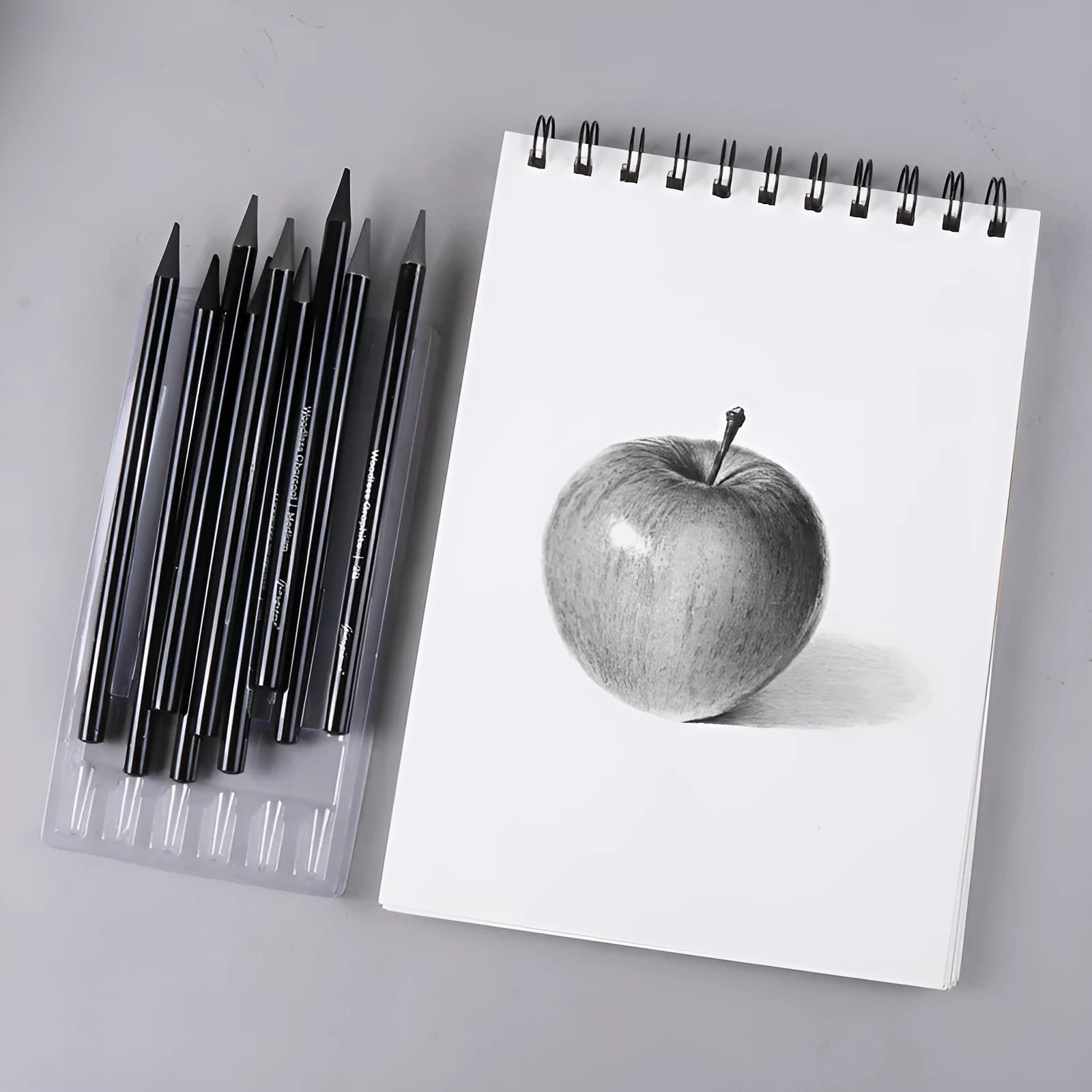 Set of six graphite and three carbonised drawing pencils on suction card packaging
