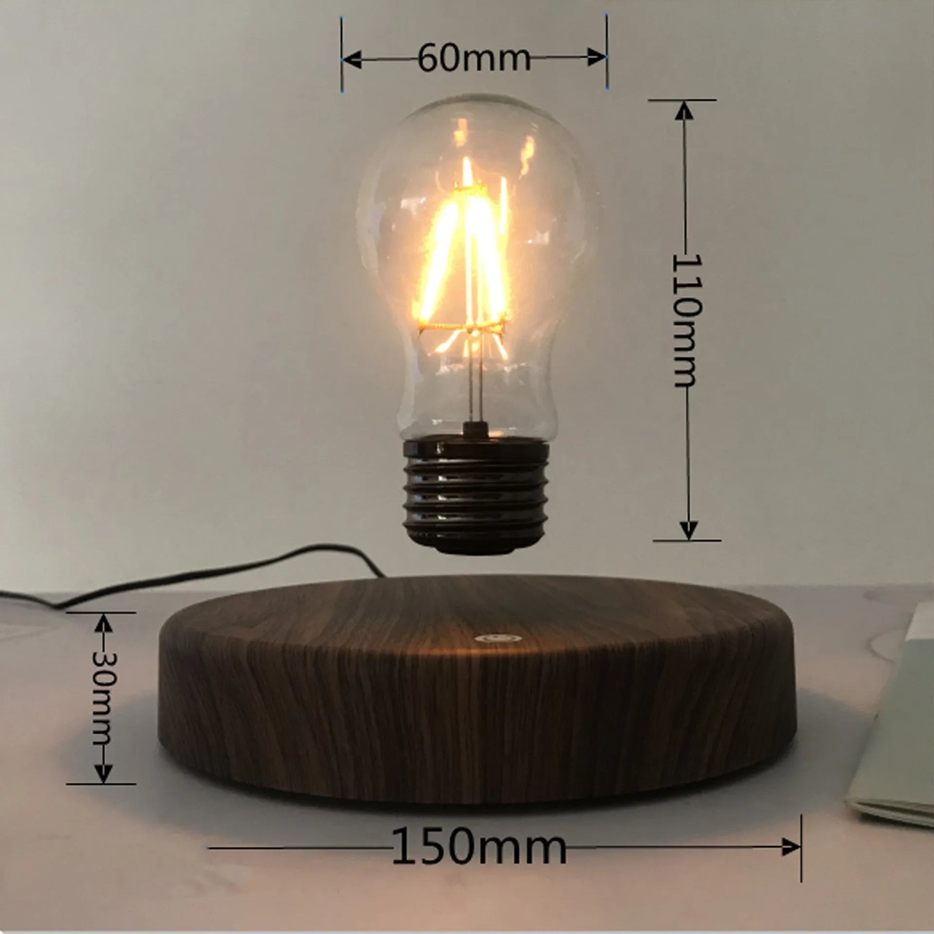 Magnetic levitation bulb night light in solid wood colour with UK plug on a desk.