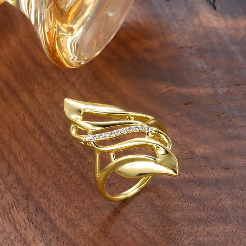Gold-coloured copper women's ring with exaggerated curve design on finger