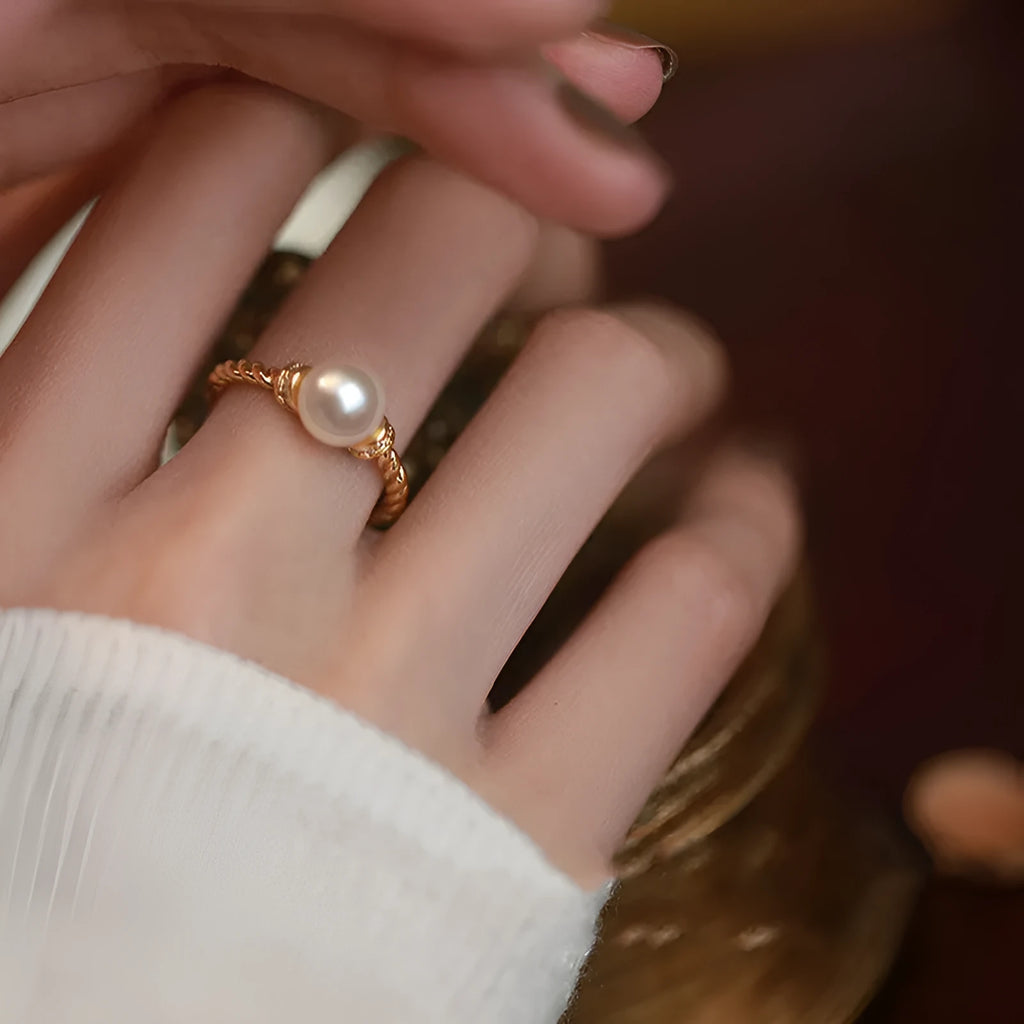 Adjustable antique twist copper ring with an inlaid pearl in gold colour.