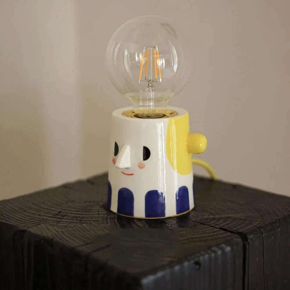 Handmade ceramic bedside lamp with a spherical ball headlight design on a ceramic base.