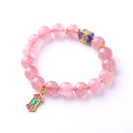 Close-up of hand-woven pink strawberry quartz crystal bracelet with Ruyi motif design