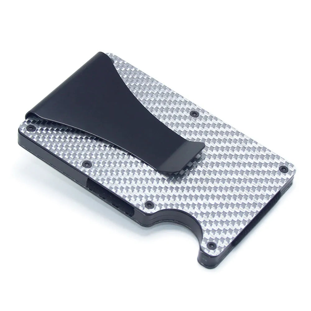 Geometric carbon fibre and aluminium business card holder, 8mm thick, on a table.