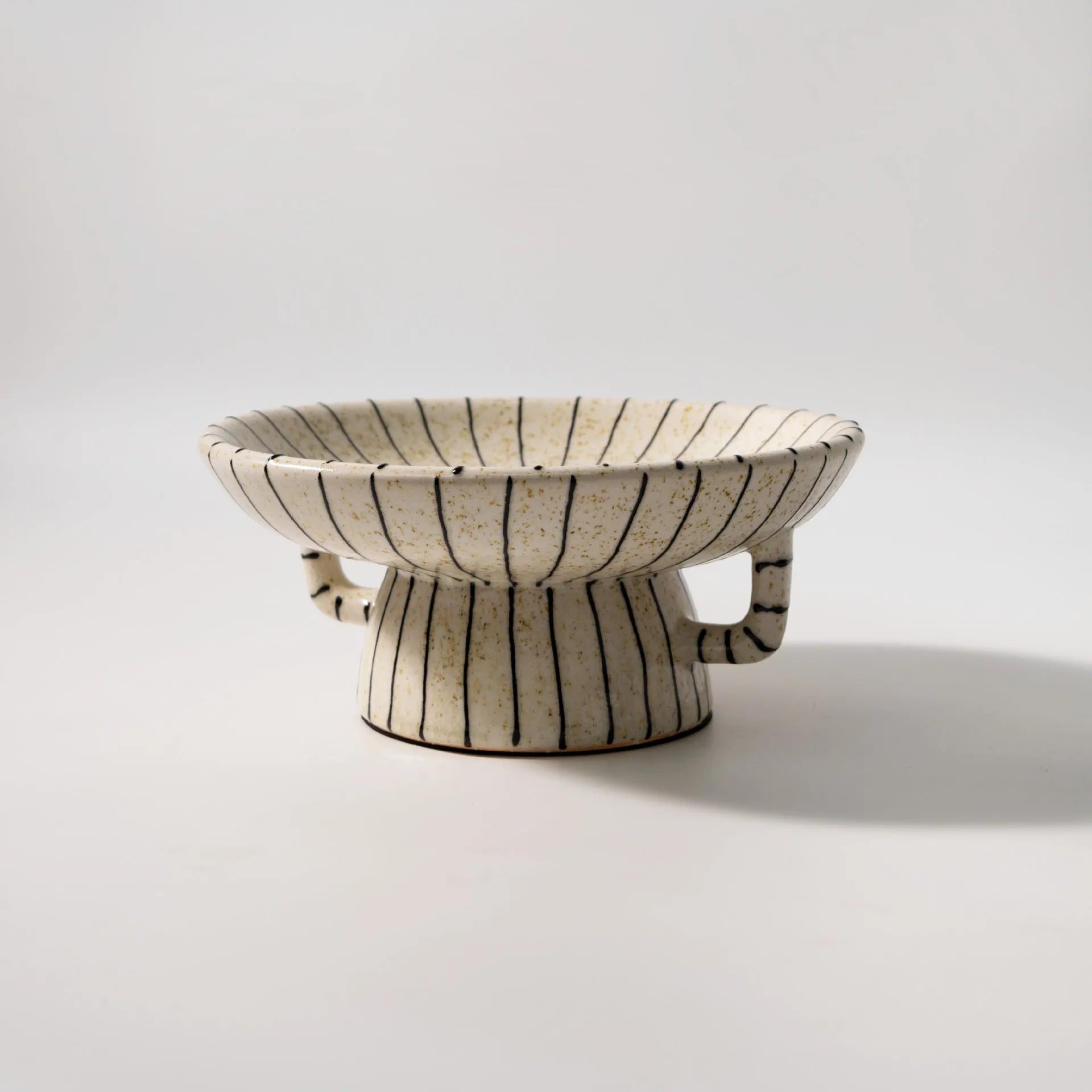 Black and white striped synthetic resin fruit dessert plate on a table