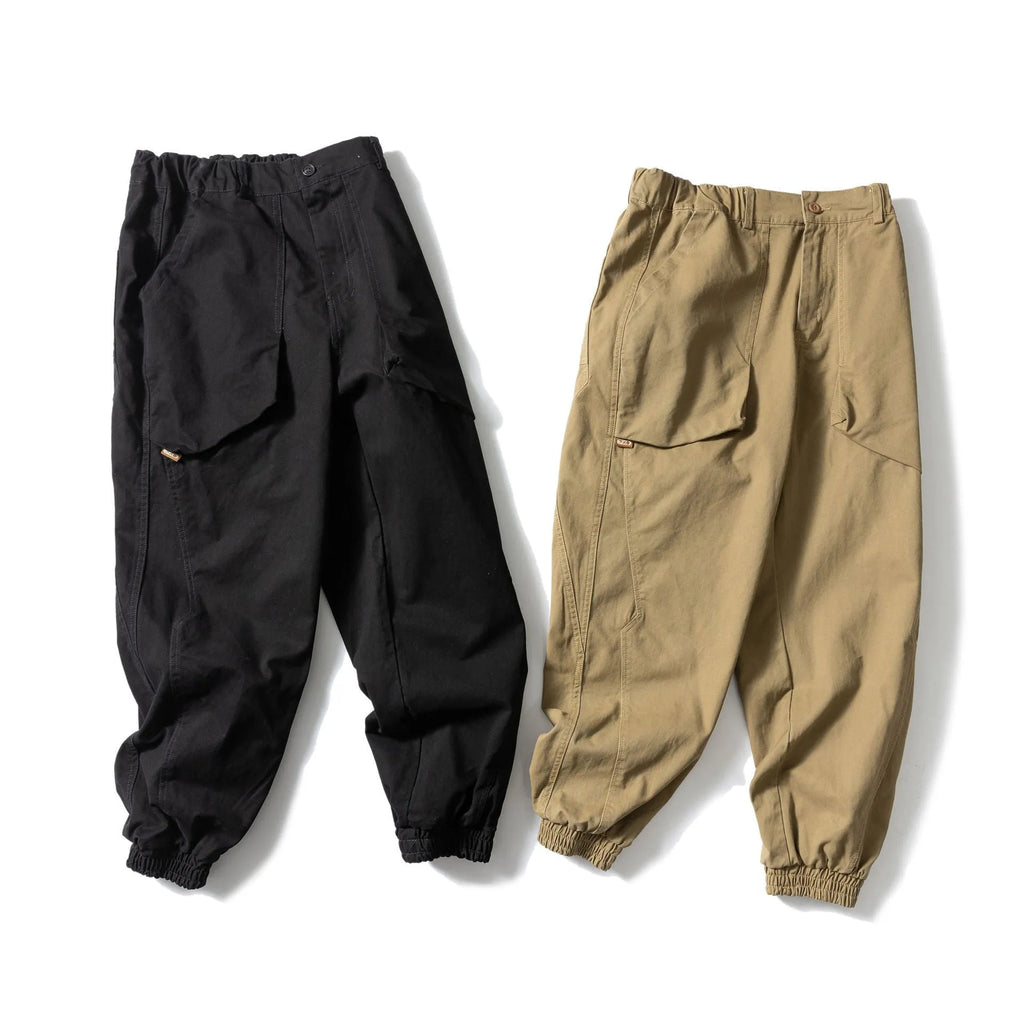 Black cotton tapered casual pants with ankle tie and large pocket.