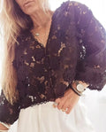 Women's loose fit V-neck lace cardigan with 3D flower decorations and hollow long sleeves in black.