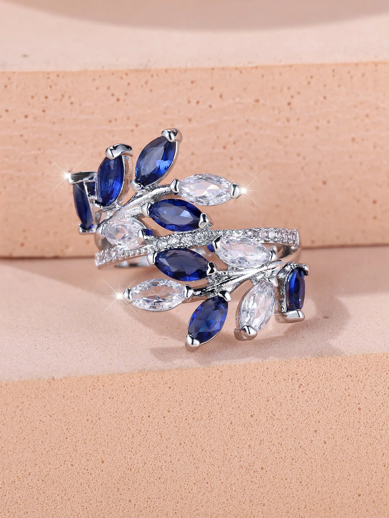 Adjustable copper ring with a detailed leaf design and zircon accents in various colour options.