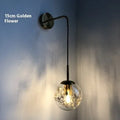 Modern glass wall lamp in golden flower or silver flower finish, shown in 15cm and 20cm sizes.