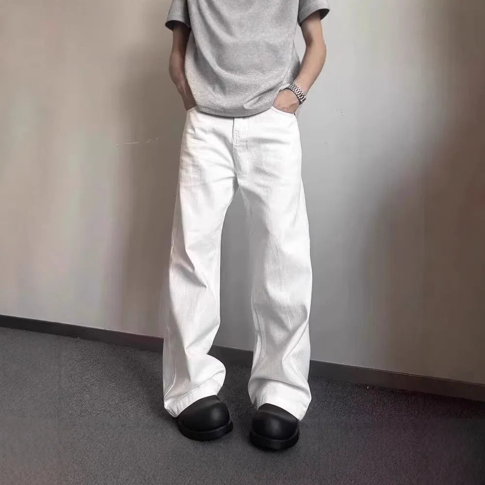 Men's loose fit straight wide leg white cotton denim jeans on a mid waist, showing zipper fly.