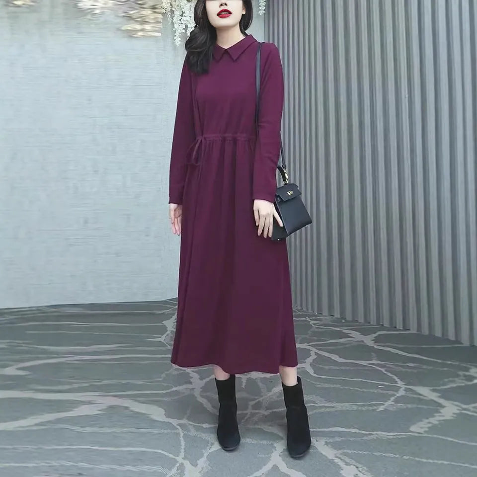 A purplish red long sleeve plus size dress for women, shown with extra-long sleeves and a long skirt.