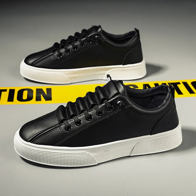 Men's black and white low top synthetic leather sports shoes with PVC sole on a plain background.