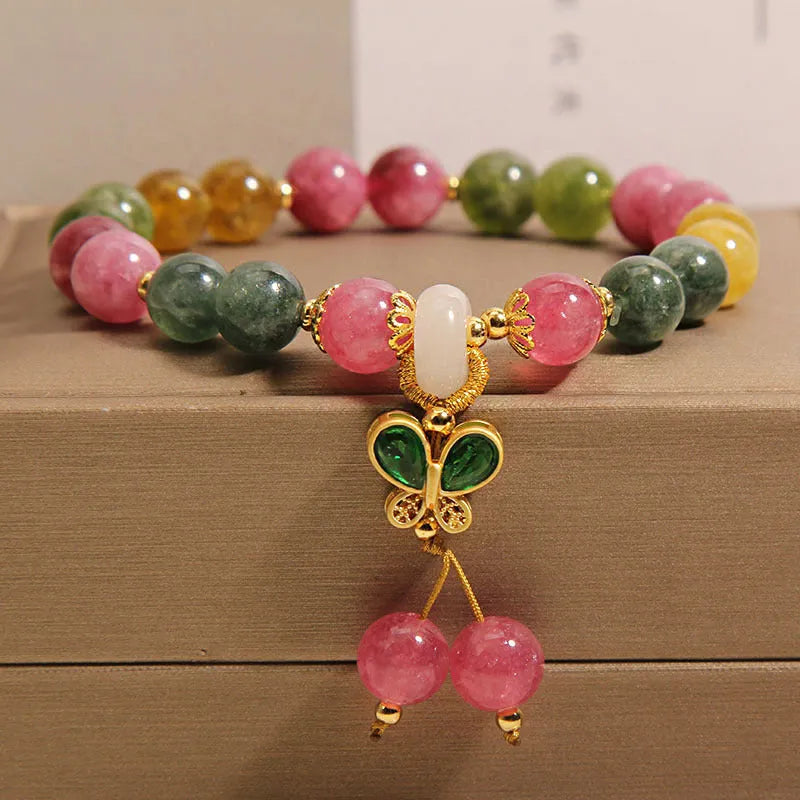 Women's bracelet with natural jade colour tourmaline butterfly pendant and rhinestone accents on alloy setting.