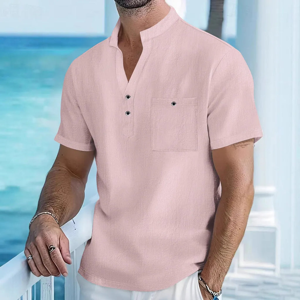 A man wearing a light blue linen stand collar short-sleeve shirt, showing the loose fit and structured neckline.