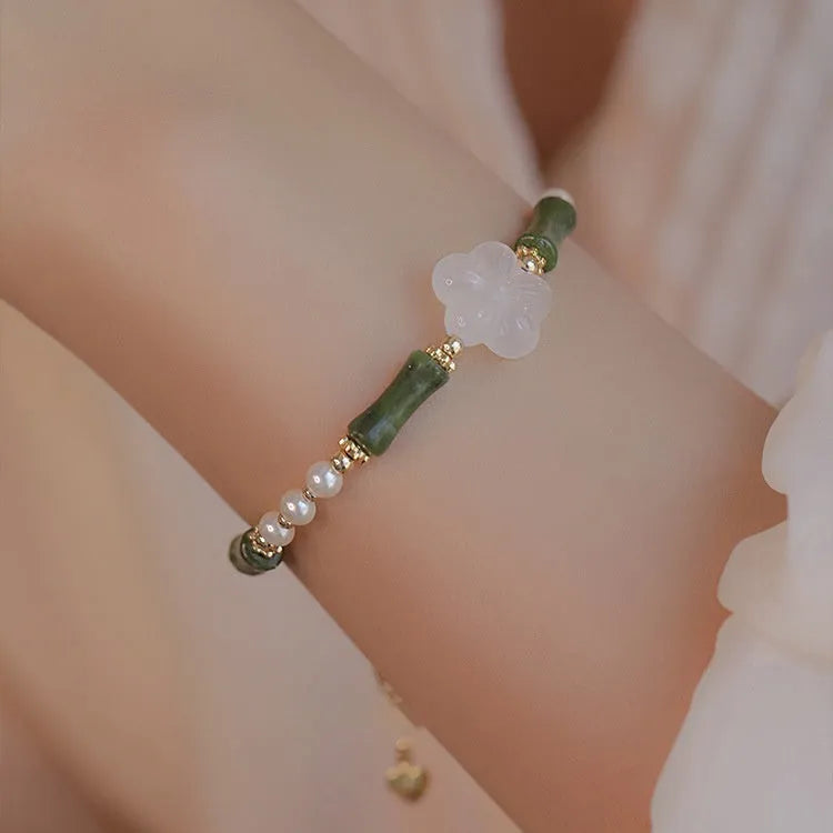 Handmade antique style bracelet with Hetian jade, copper shell pearls, and bamboo joint detail.