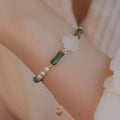 Handmade antique style bracelet with Hetian jade, copper shell pearls, and bamboo joint detail.
