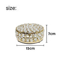 French gold metal jewelry box with a clear crystal glass lid and a lock, shown on a surface.