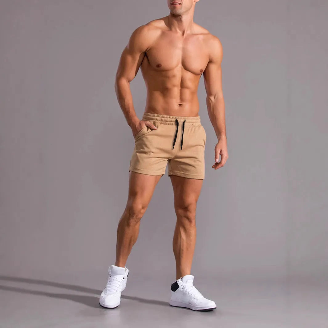 A pack of three men's solid colour drawstring shorts in black, khaki, and light brown, laid flat.