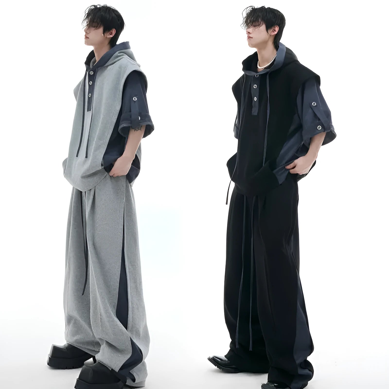 Man wearing a black hooded short-sleeve leisure jacket with textured stitching and matching trousers.
