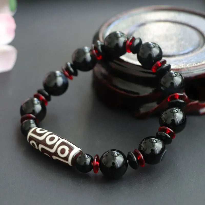 Black agate dzi bead bracelet with geometric 11mm beads on a hand-woven cord.