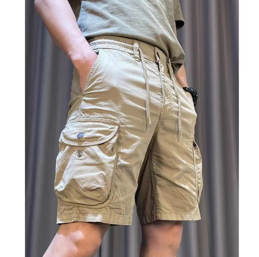 A model wearing loose, straight-leg multi-pocket casual overalls in a khaki colour.