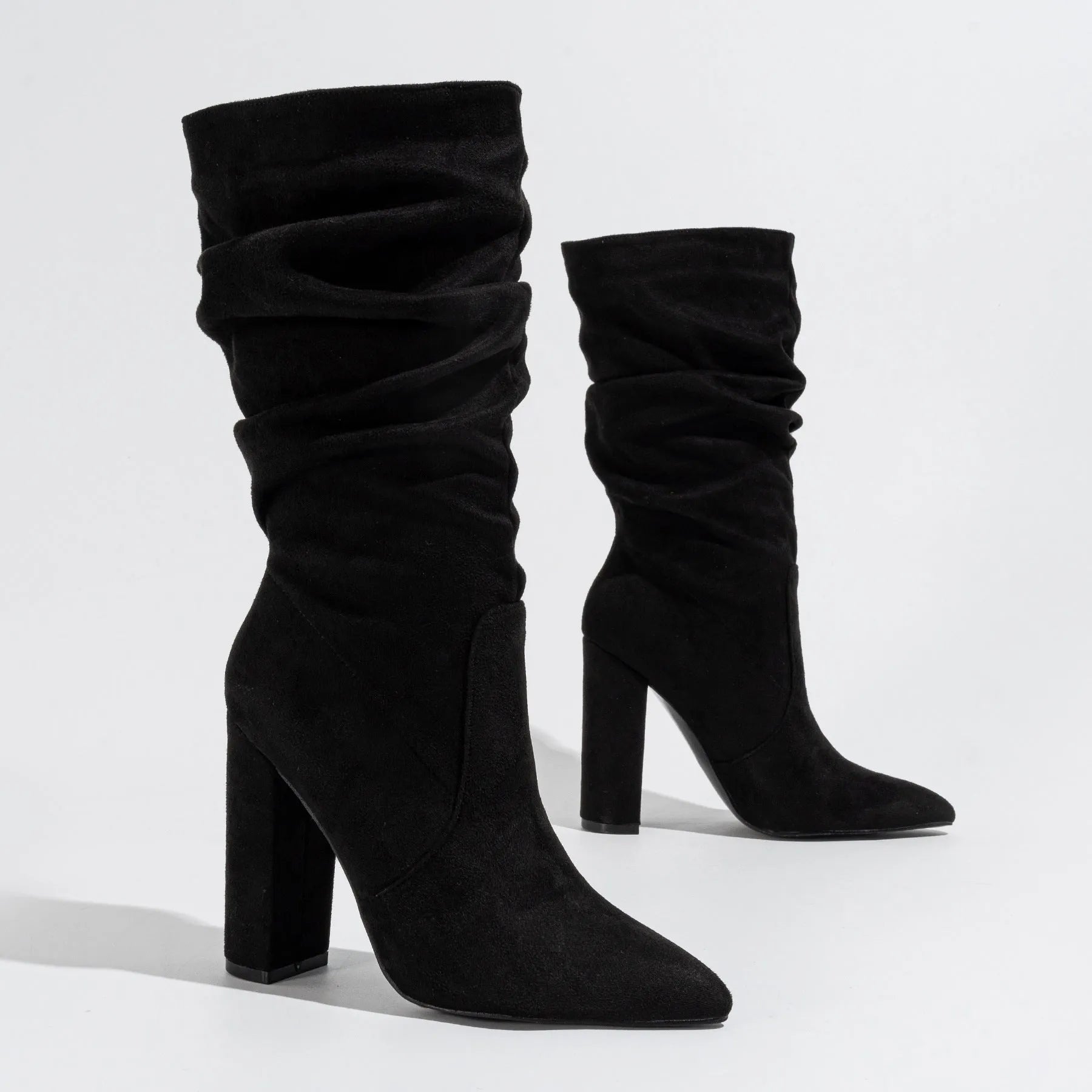 Women's black suede chunky high heel boots with pointed toe and mid-calf length.