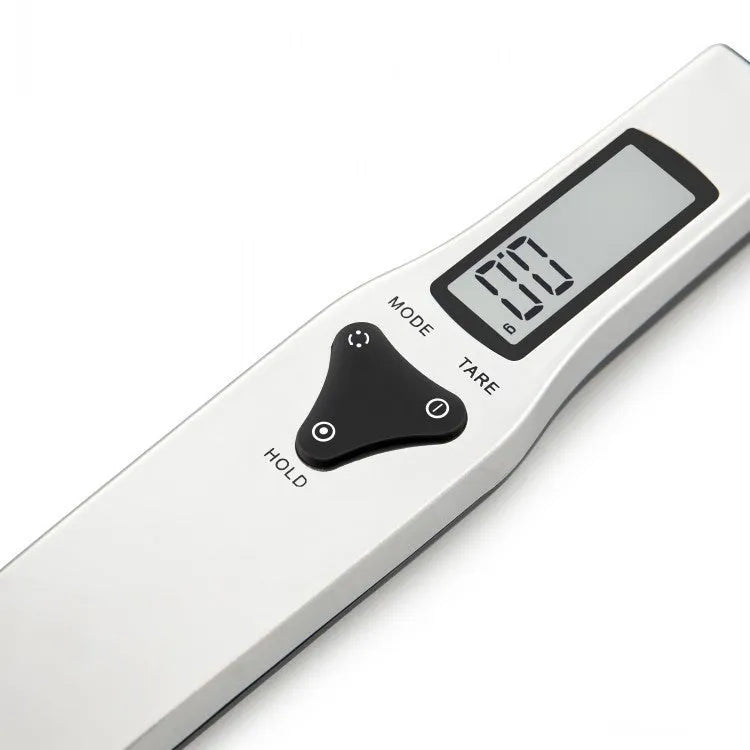 Digital smart measuring spoon with LCD screen showing weight, placed next to mixing bowl.