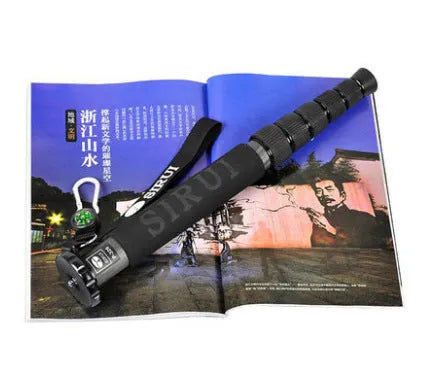 Black carbon fibre telescopic camera monopod fully extended to 1540mm next to an SLR