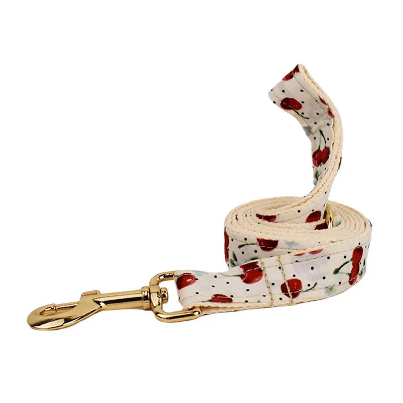 Red cherry printed dog collar with light gold buckle and matching leash set with bow accessory