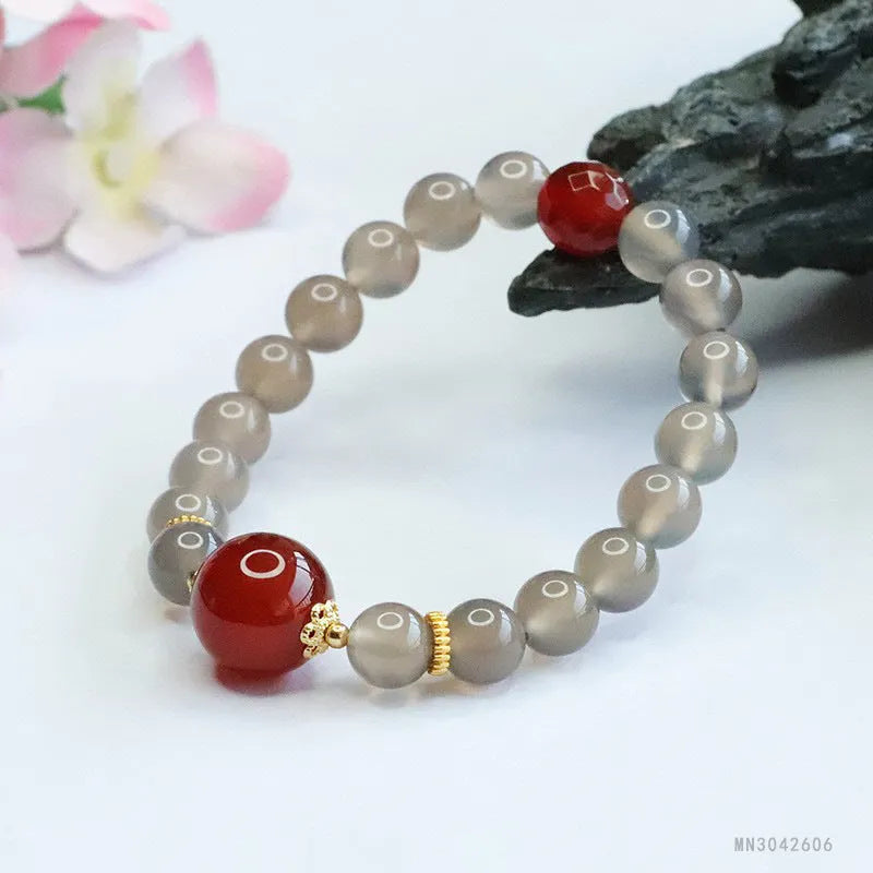 Smoky purple and red agate bracelet with 8mm geometric beads on a wrist.