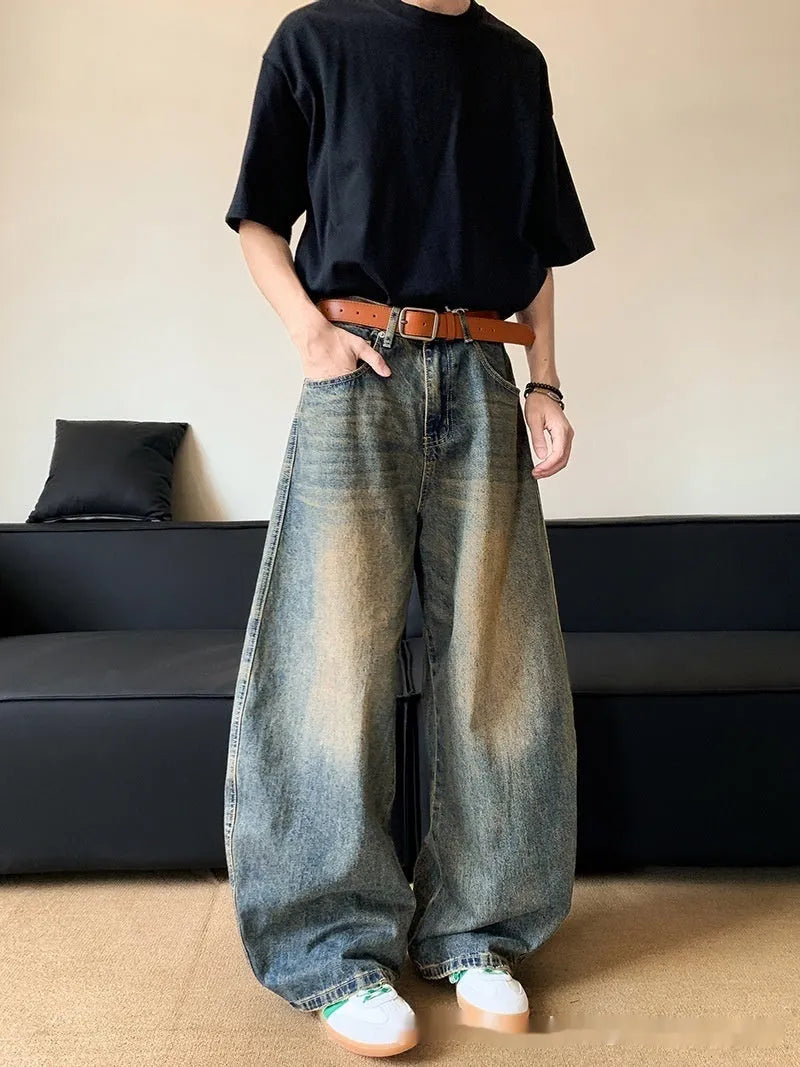 Men's retro blue distressed denim jeans with slim fit wide leg design showing machete wash detailing