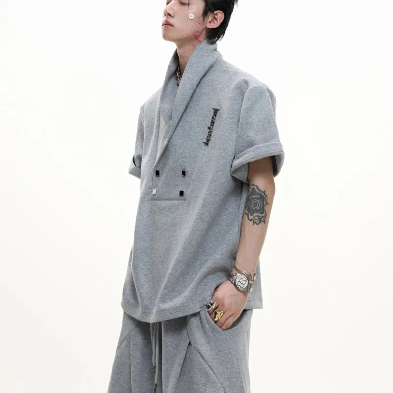 Men's dark grey V-neck cotton sports jacket with padded shoulders and metal details, paired with matching shorts.