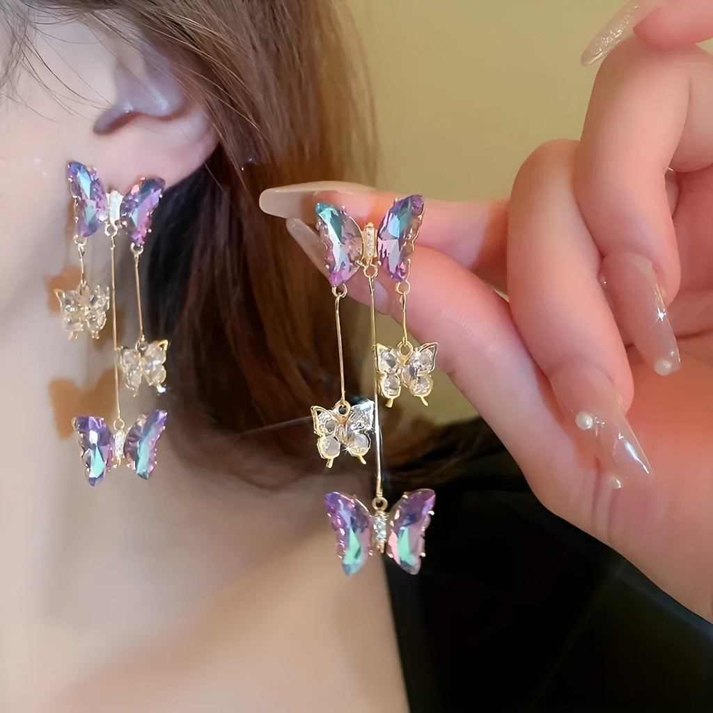 A pair of blue purple butterfly coloured alloy earrings with crystal flowers and a drop tassel.