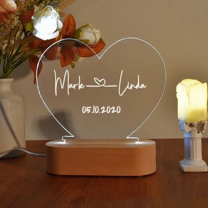 Custom transparent acrylic night light showing personalised names and date, lit by an LED base.