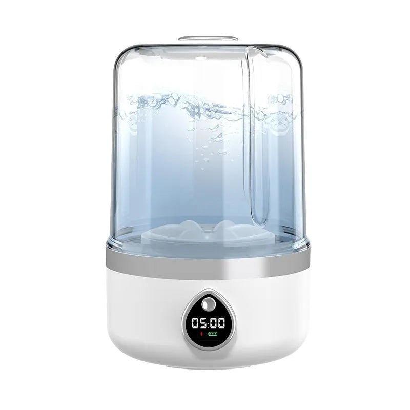Small white portable washing machine with USB cable on a countertop.