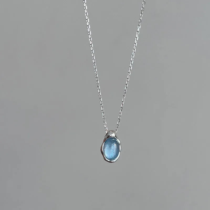 Geometric navy blue and platinum water drop pendant necklace on an adjustable copper cross chain.