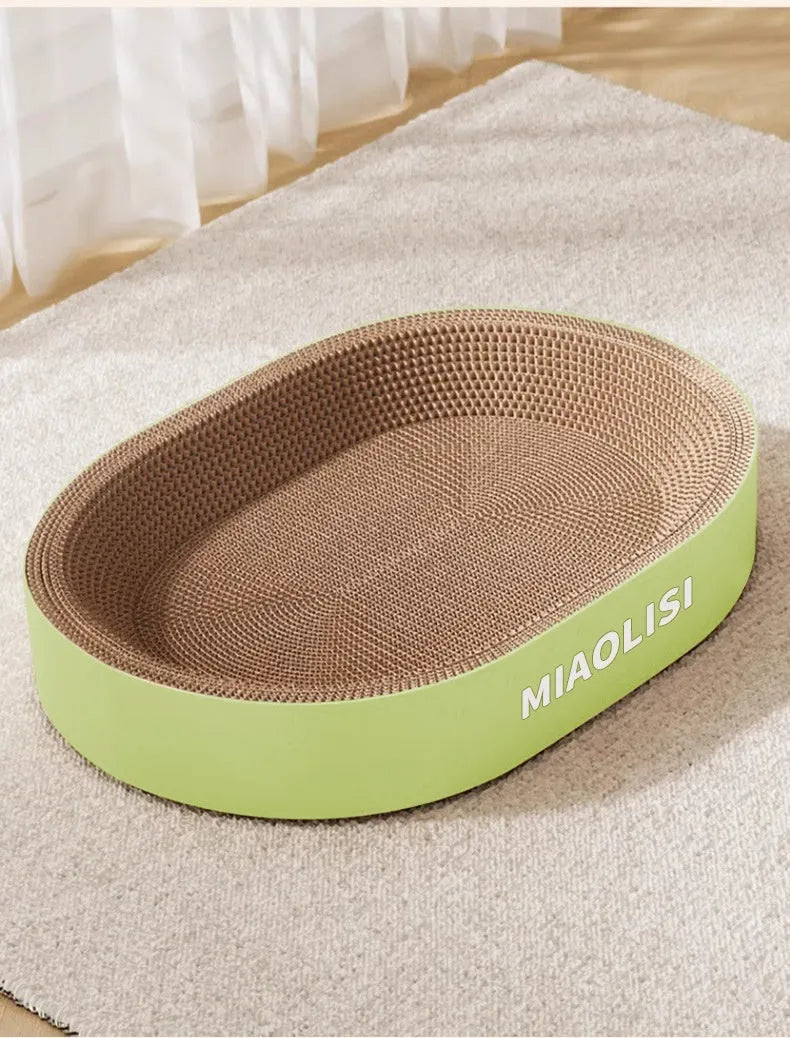 Green oval corrugated paper cat scratch board and nest bed for cats on a wooden floor.