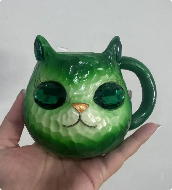 American-style resin ornament of a cat holding a crystal Earth globe in blue, green, pink, or purple.