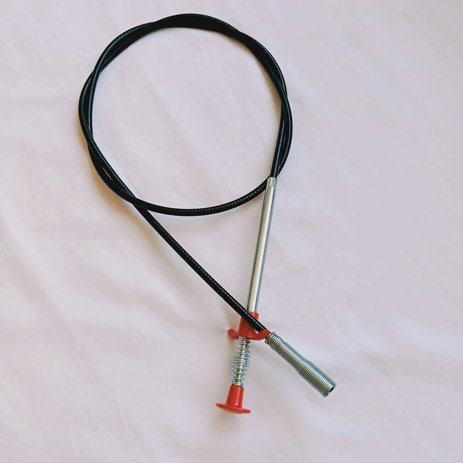 Flexible plastic and stainless steel drain cleaning spring tool with rubber grip for household pipe maintenance