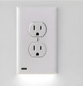 White plastic LED night light plugged into a standard UK wall socket.