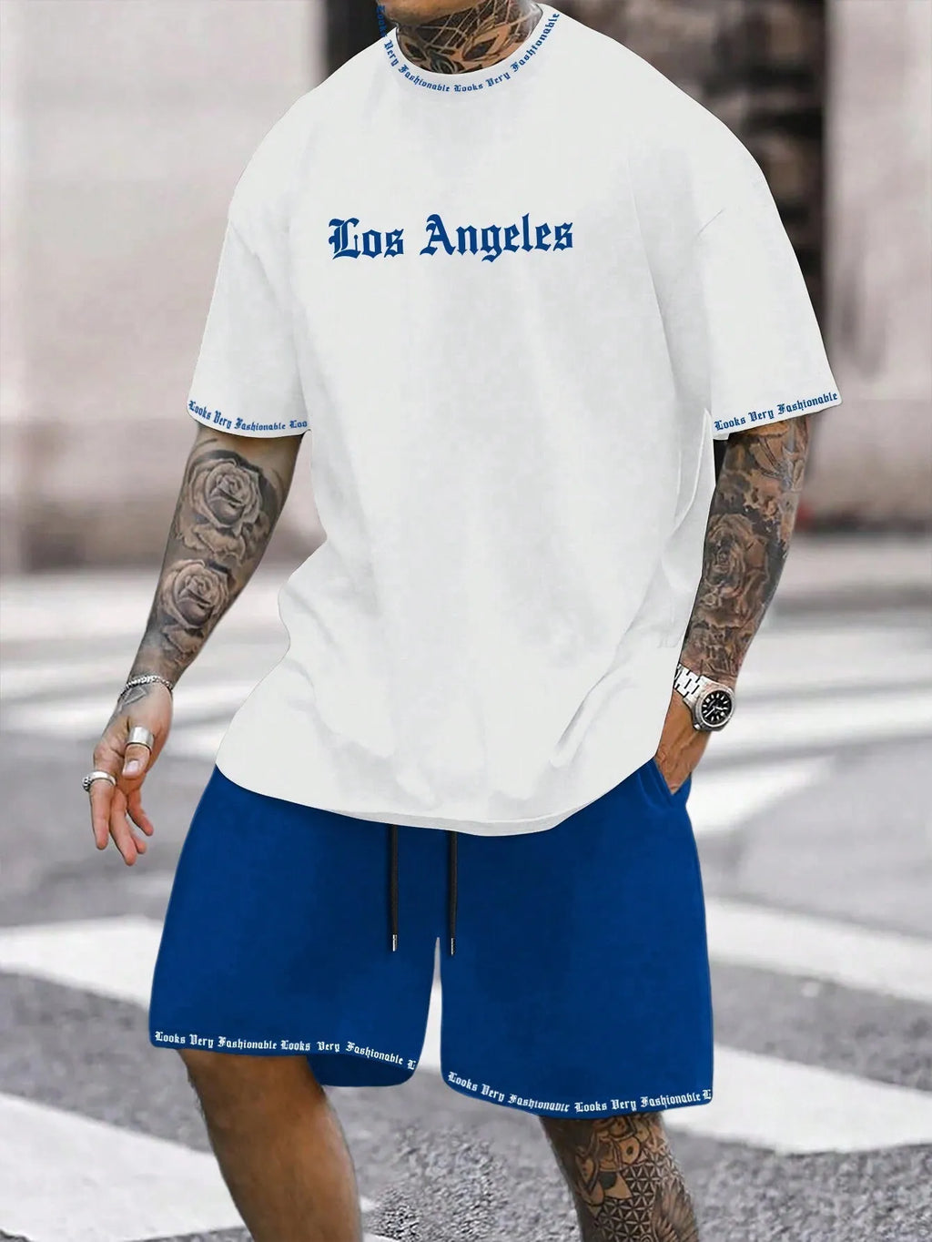 Man wearing a blue printed sports-style short-sleeve top and matching shorts set.