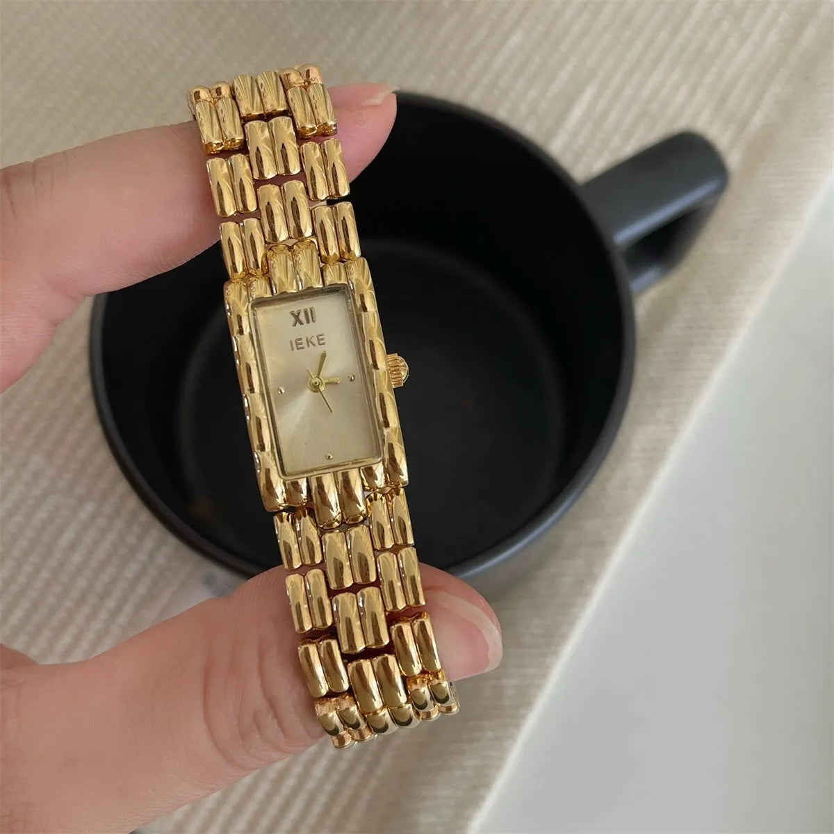 Women's bracelet watch with butterfly clasp showing 15mm dial and stainless steel case